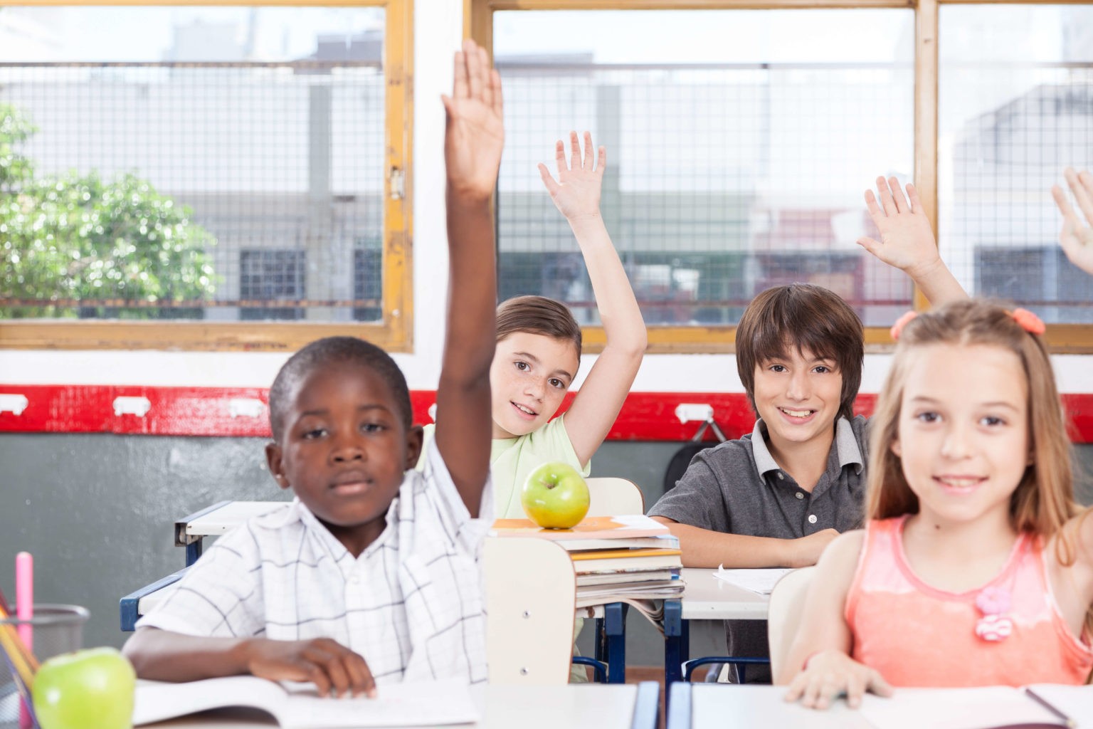 Raise children. Children in the Classroom. Kid pointing at Classroom. Kids talking in the class raising hands.