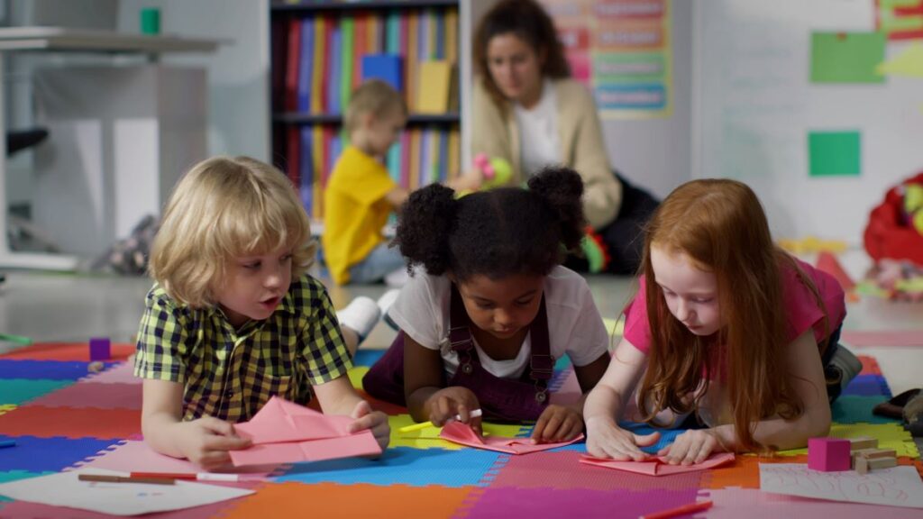 Three young students do an arts and crafts activity.
