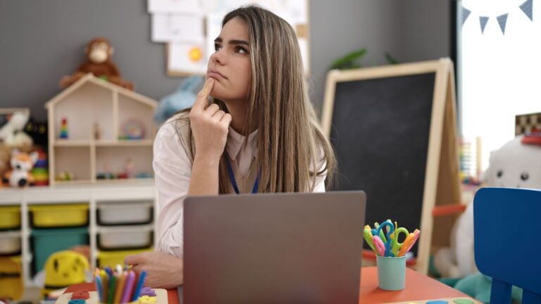 A teacher sits in her classroom representing teaching and learning.