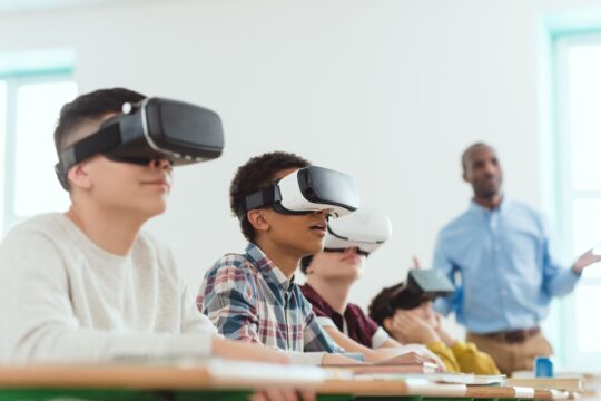 A group of students using virtual reality headsets in the classroom.