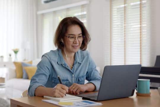 Online professional development: a teacher sits on her personal laptop at home, taking a course.
