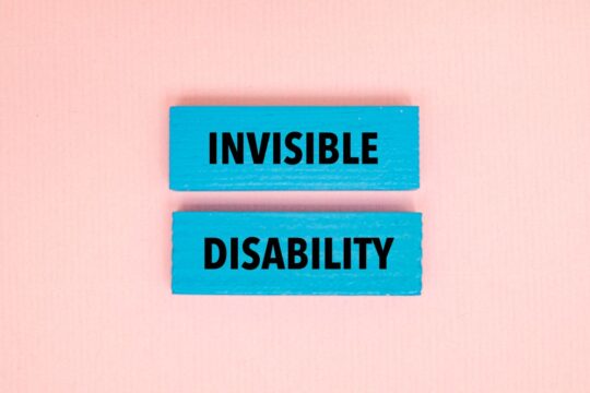 Two wooden blocks with writing on them that says, “invisible disabilities.”