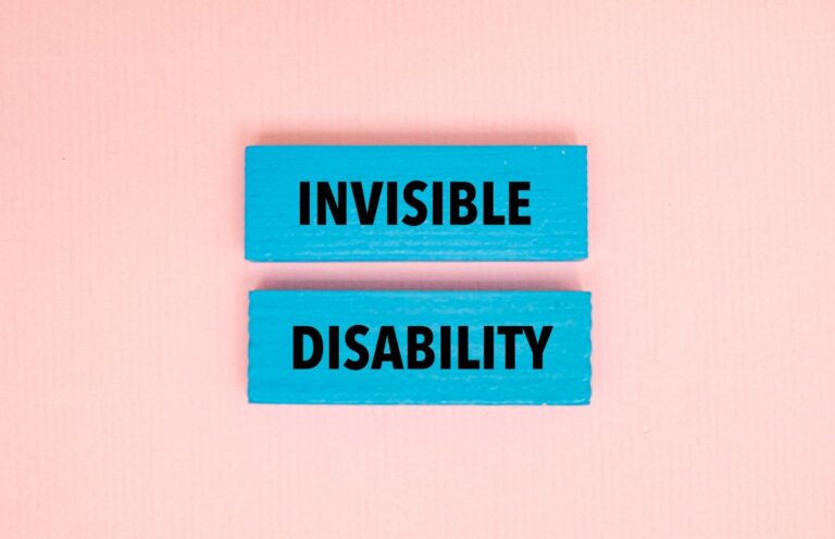 Two wooden blocks with writing on them that says, “invisible disabilities.”