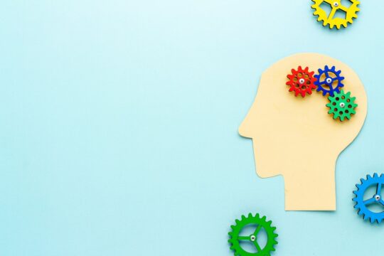 Paper head with brain of gears and cogs.