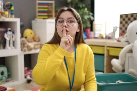A teacher shushing her noisy classroom.